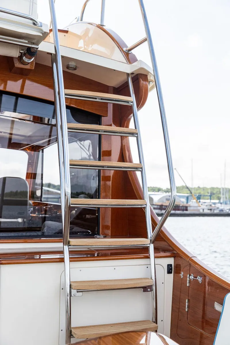 Slide: The Image of Hinckley Talaria 43 Flybridge 2017 yacht ladder with polished wood and metal finish. - 9