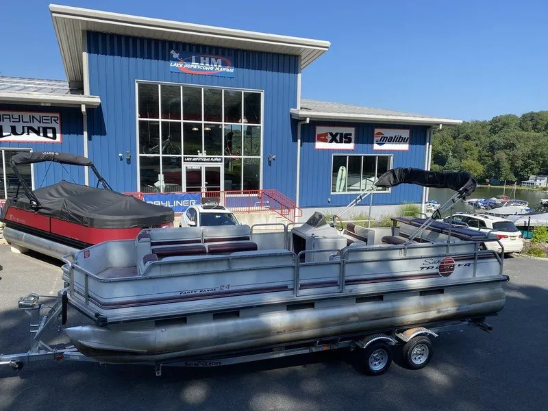 The Image of 1994 Sun Tracker Party Barge 24 pontoon boat on trailer outside dealership. - 0