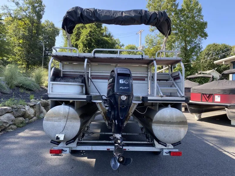 Slide: The Image of 1994 Sun Tracker Party Barge 24 pontoon boat with outboard motor, parked on trailer. - 5