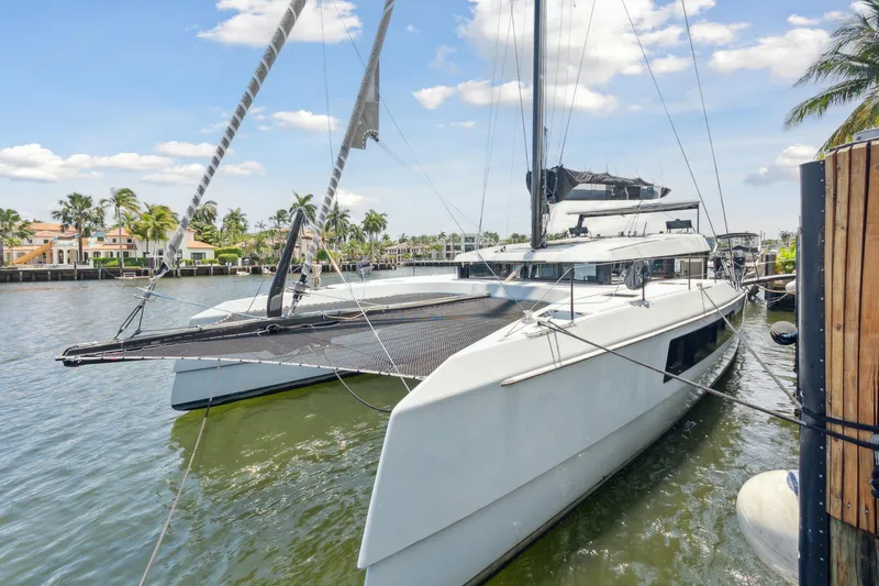 The Image of 2019 McConaghy MC60 catamaran docked in a scenic waterfront setting. - 0