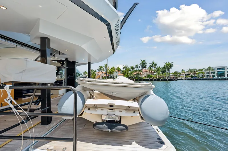 Slide: The Image of 2019 McConaghy MC60 yacht with tender, docked by waterfront homes under a sunny sky. - 11