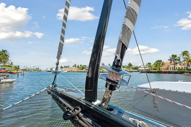Slide: The Image of 2019 McConaghy MC60 sailboat on a sunny waterfront, showcasing rigging and netting. - 16