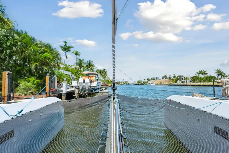 Slide: The Image of 2019 McConaghy MC60 catamaran docked in a tropical marina setting. - 18