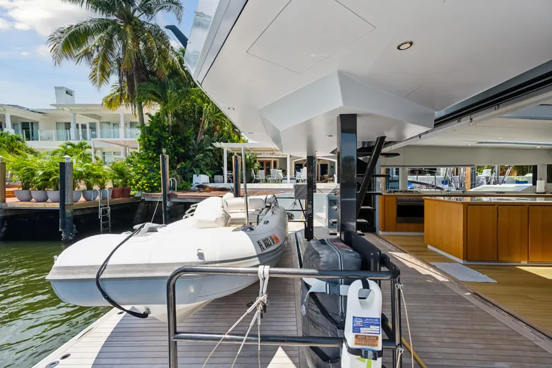 Slide: The Image of 2019 McConaghy MC60 yacht deck with tender, docked near tropical waterfront property. - 24