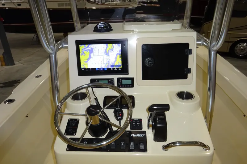 Slide: The Image of Control panel of a 2012 Parker 21 Special Edition boat with navigation screen and steering wheel. - 37