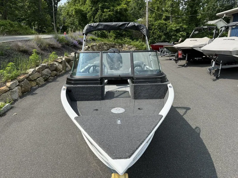 Slide: The Image of 2025 Lund 1775 Adventure Sport boat parked on a driveway, surrounded by greenery. - 16