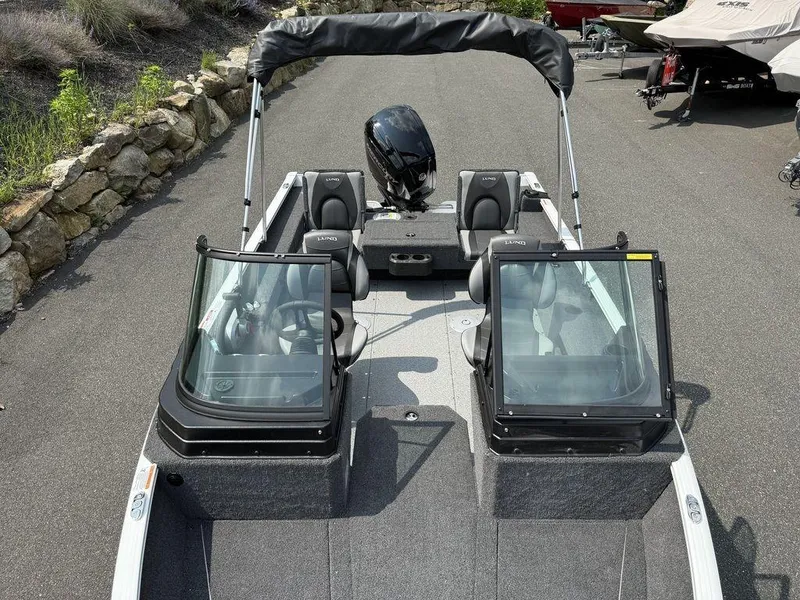 Slide: The Image of 2025 Lund 1775 Adventure Sport boat with dual consoles and seating, parked on pavement. - 3