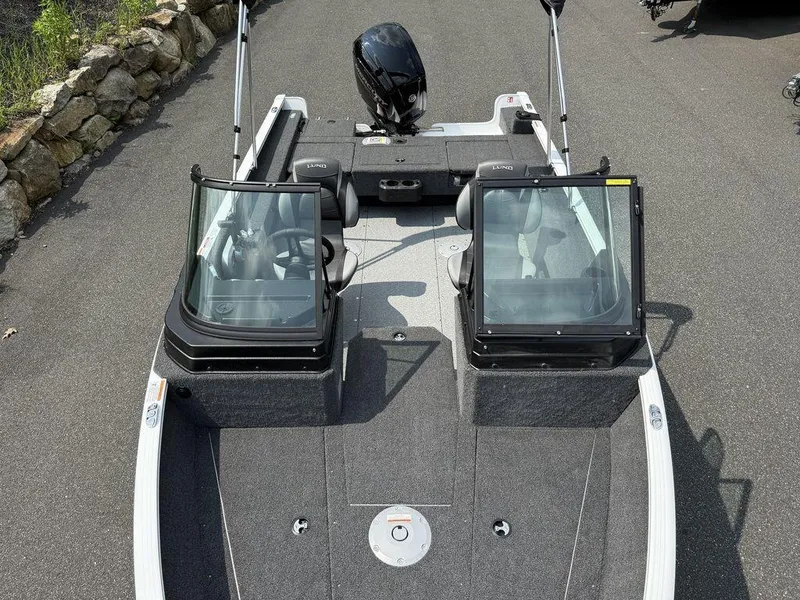 Slide: The Image of 2025 Lund 1775 Adventure Sport boat with dual consoles and outboard motor on a paved surface. - 5