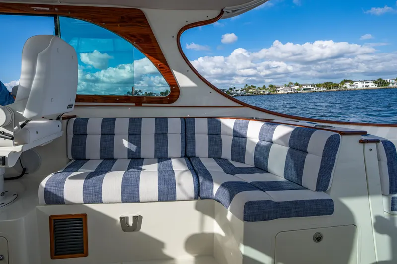 Slide: The Image of Interior of 2024 Hinckley 35 boat with striped seating, overlooking water and sky. - 12