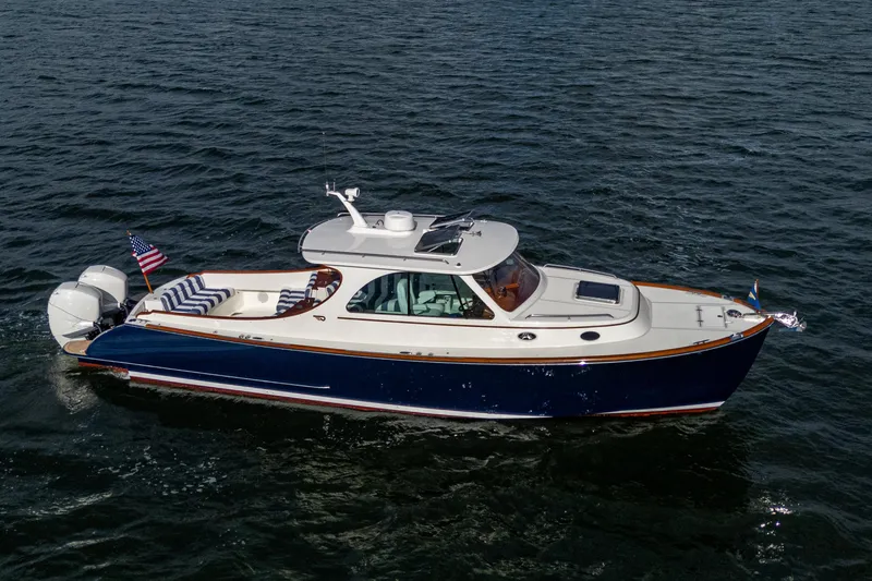 The Image of 2024 Hinckley 35 boat cruising on open water, featuring sleek design and American flag. - 0