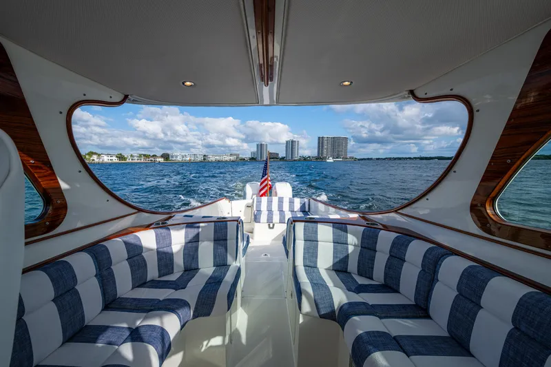 Slide: The Image of 2024 Hinckley 35 yacht interior with striped seating, overlooking ocean and city skyline. - 10