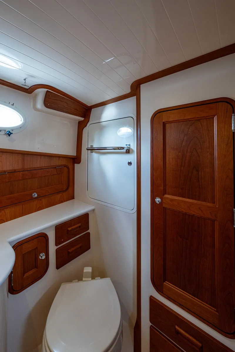 Slide: The Image of 2024 Hinckley 35 yacht bathroom with wooden cabinetry and modern fixtures. - 23