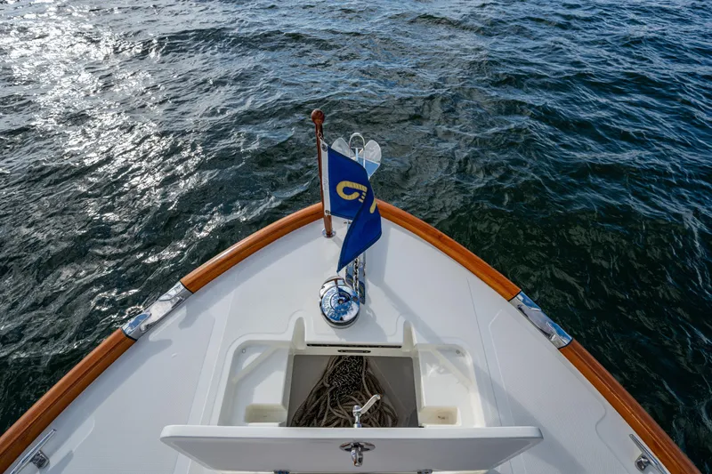 Slide: The Image of Bow of 2024 Hinckley 35 boat with flag, on water. - 26
