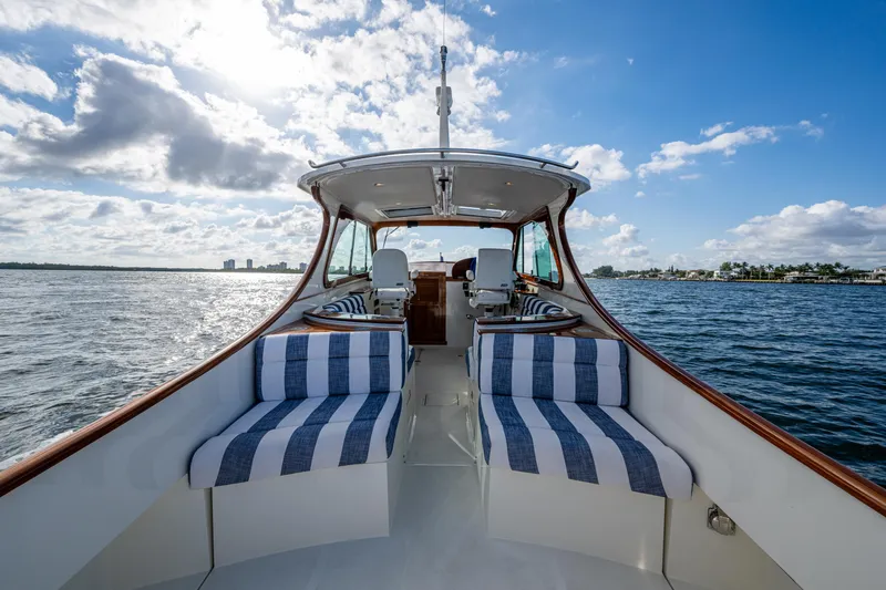 Slide: The Image of 2024 Hinckley 35 yacht interior with striped seating, cruising on open water under a partly cloudy sky. - 9