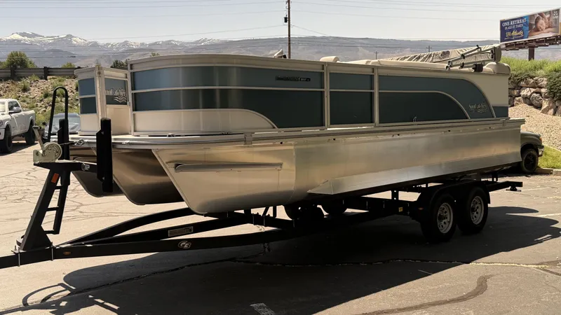 Slide: The Image of 2023 SunCatcher Select 322FC pontoon boat on a trailer, parked outdoors. - 2