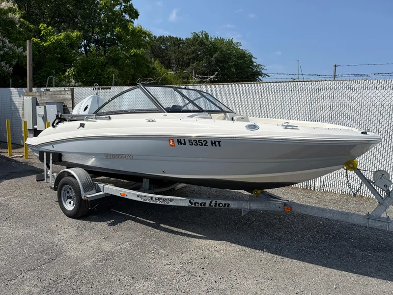 Slide: The Image of 2023 Stingray 191 DC boat on trailer, parked outdoors. - 1