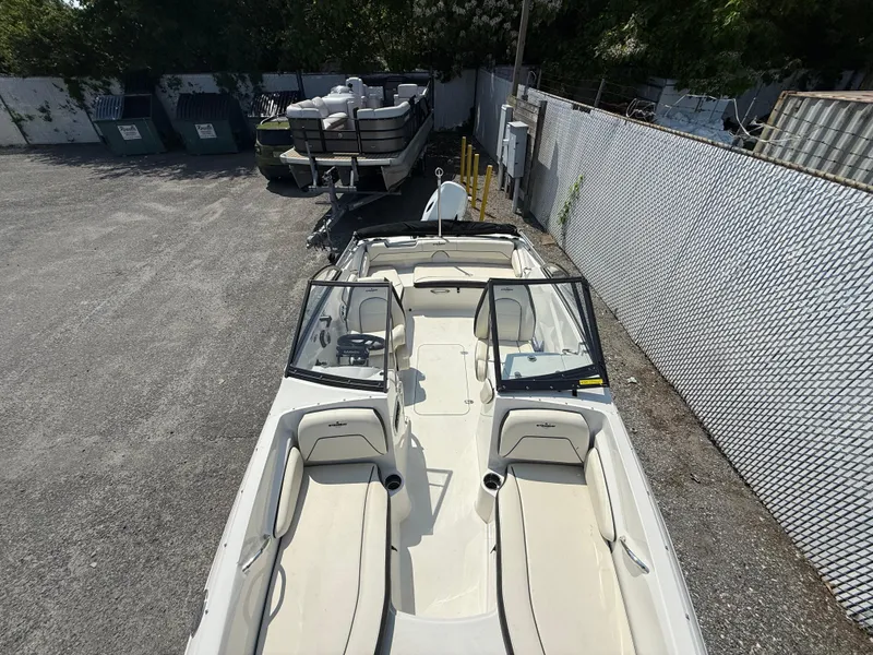 Slide: The Image of 2023 Stingray 191 DC boat with open seating, parked in a fenced area. - 10