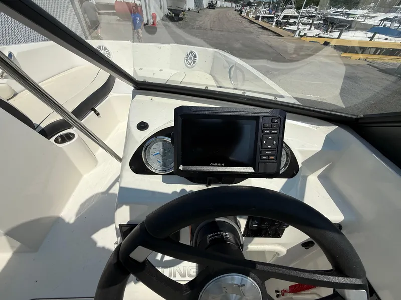 Slide: The Image of 2023 Stingray 191 DC boat dashboard with steering wheel and navigation display. - 11