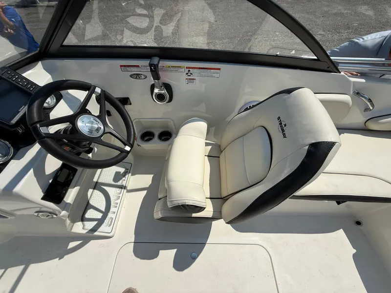 Slide: The Image of 2023 Stingray 191 DC boat interior with steering wheel and comfortable seating. - 12