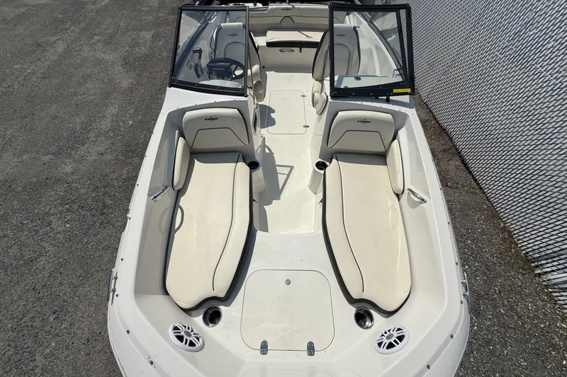 Slide: The Image of 2023 Stingray 191 DC boat interior with beige seating and open windshield. - 14