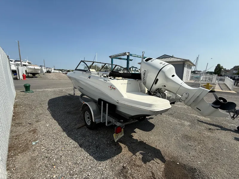 Slide: The Image of 2023 Stingray 191 DC boat on trailer, parked outdoors under clear sky. - 5