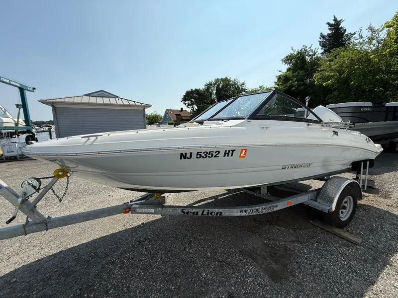 Slide: The Image of 2023 Stingray 191 DC boat on trailer, parked outdoors, sunny day. - 7