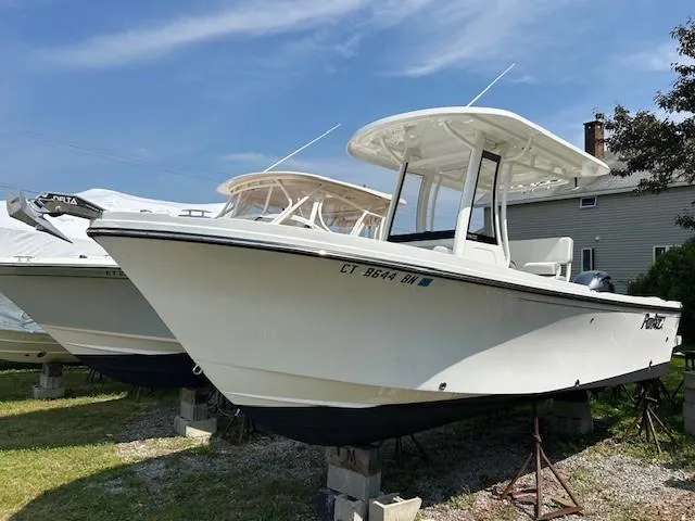 The Image of 2022 Parker 2200 Center Console boat docked at marina, reflecting on calm water. - 0