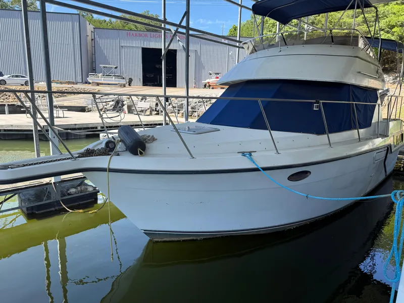 The Image of 1994 Carver 300 boat docked in marina, covered with blue canopy. - 0