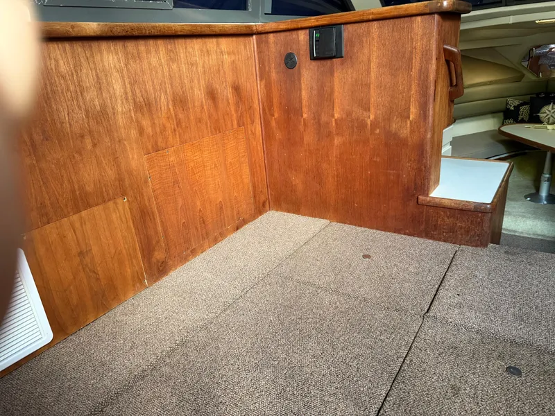 Slide: The Image of Interior of a 1994 Carver 300 boat with wood paneling and carpeted flooring. - 16
