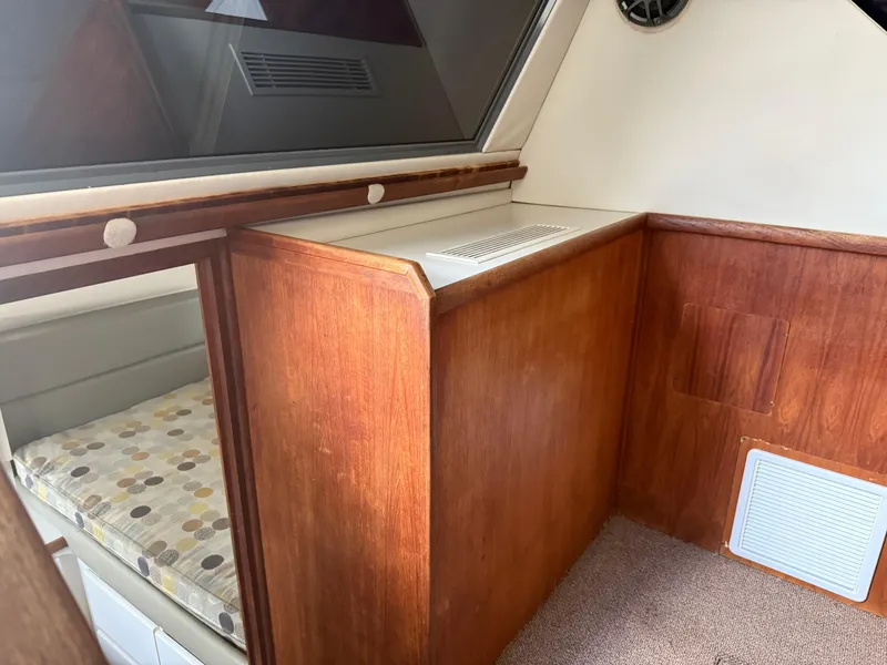 Slide: The Image of Interior of a 1994 Carver 300 boat, featuring wood paneling and a cushioned seating area. - 21