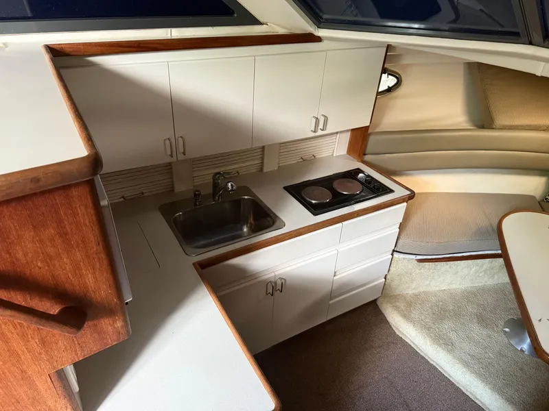 Slide: The Image of 1994 Carver 300 yacht interior kitchen with sink, stove, and cabinets. - 22