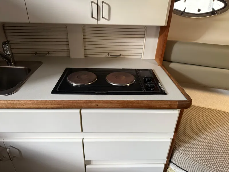 Slide: The Image of 1994 Carver 300 yacht kitchen with stove, sink, and storage cabinets. - 26