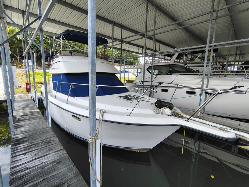 Slide: The Image of 1994 Carver 300 boat docked in a covered marina. - 8