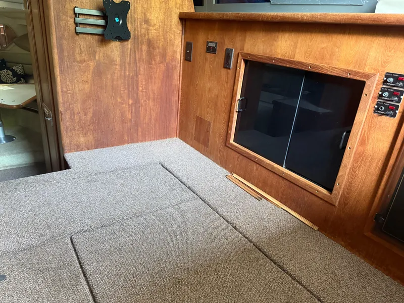 Slide: The Image of Interior of a 1994 Carver 300 boat with wood paneling and carpeted flooring. - 15