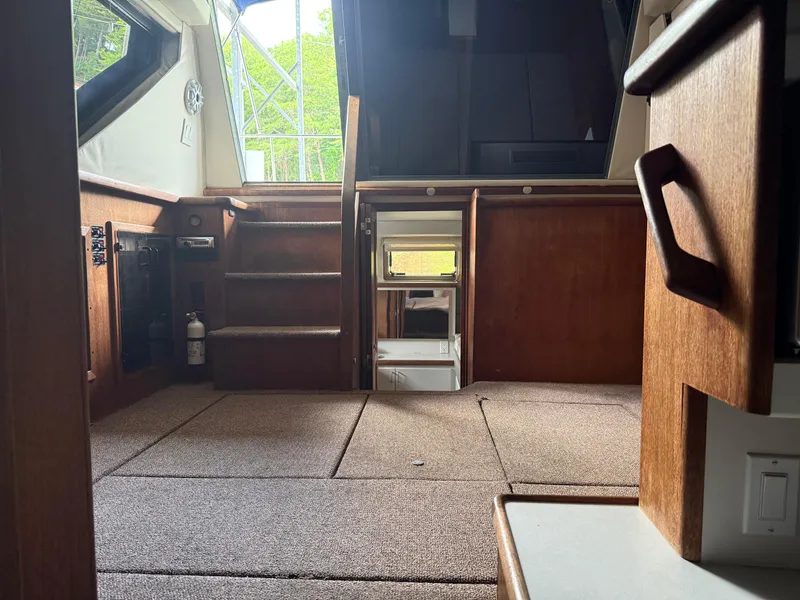 Slide: The Image of Interior of a 1994 Carver 300 boat, featuring carpeted flooring and wooden cabinetry. - 18