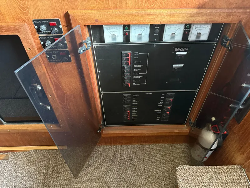 Slide: The Image of Electrical panel of a 1994 Carver 300 boat with open doors and fire extinguisher. - 19