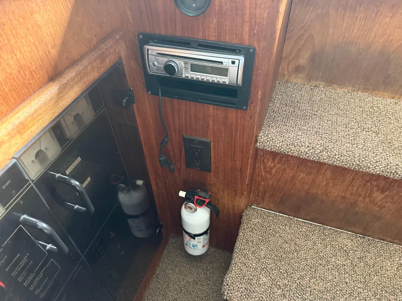Slide: The Image of Interior of 1994 Carver 300 boat with stereo, fire extinguisher, and carpeted stairs. - 20