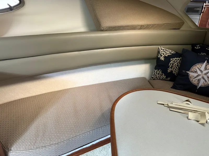 Slide: The Image of Interior of 1994 Carver 300 boat with cushioned seating and nautical-themed pillows. - 25