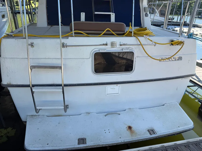 Slide: The Image of 1994 Carver 300 boat stern with ladder and yellow cable on deck. - 3