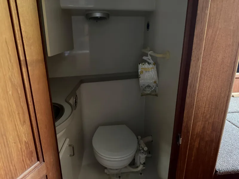 Slide: The Image of Compact bathroom in a 1994 Carver 300 boat, featuring a toilet and sink. - 31