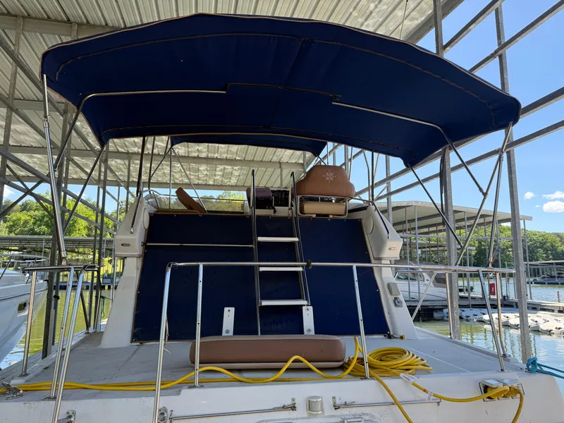 Slide: The Image of 1994 Carver 300 boat docked under a covered marina with blue canopy. - 5