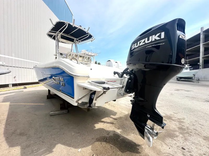 Slide: The Image of 2022 Carolina Skiff 23 Ultra Elite boat with Suzuki outboard motor, parked outdoors. - 1