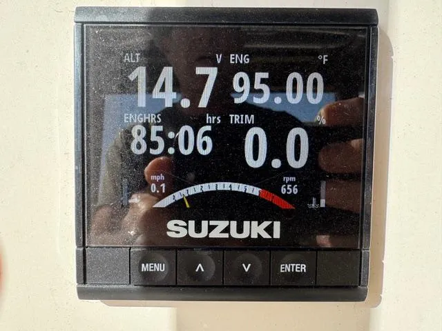 Slide: The Image of Suzuki engine display showing 14.7 volts, 95°F, 85.06 engine hours on a 2022 Carolina Skiff. - 16