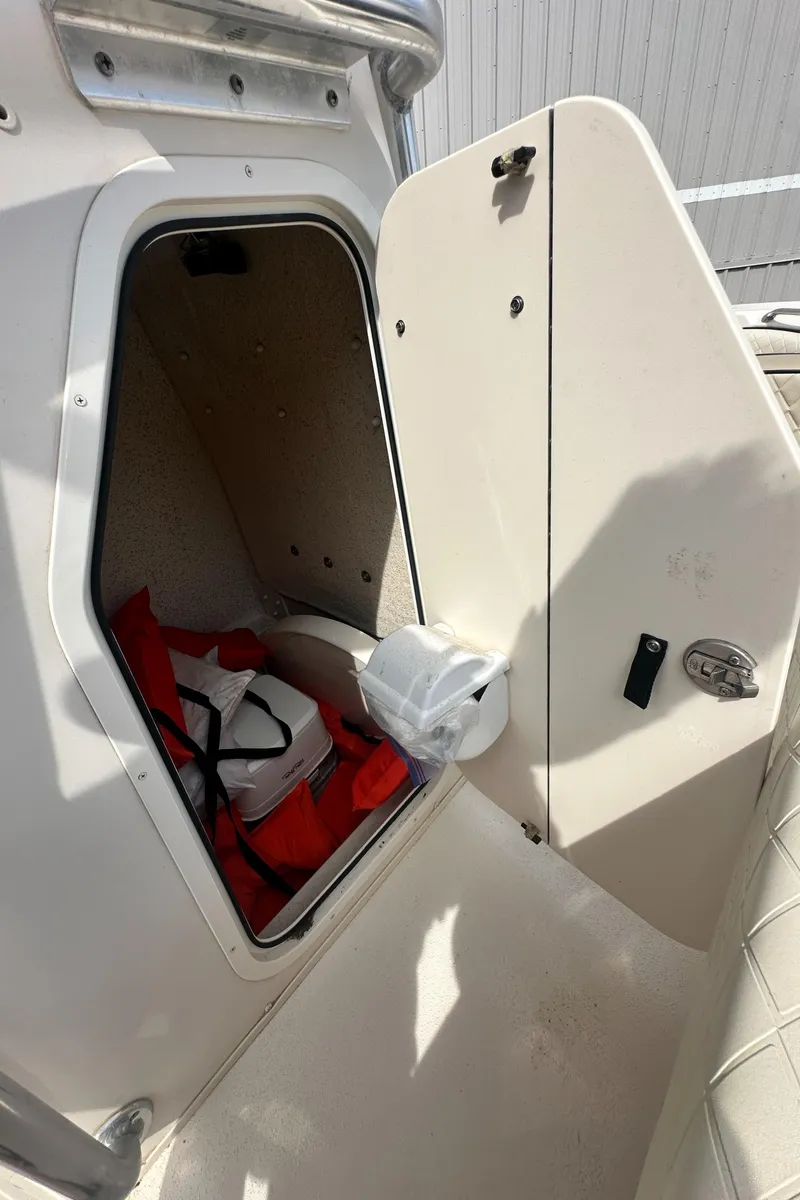 Slide: The Image of 2022 Carolina Skiff 23 Ultra Elite storage compartment with life jackets and a roll of paper. - 17
