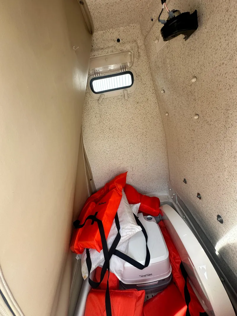 Slide: The Image of Interior storage of 2022 Carolina Skiff 23 Ultra Elite with life jackets and cooler. - 18