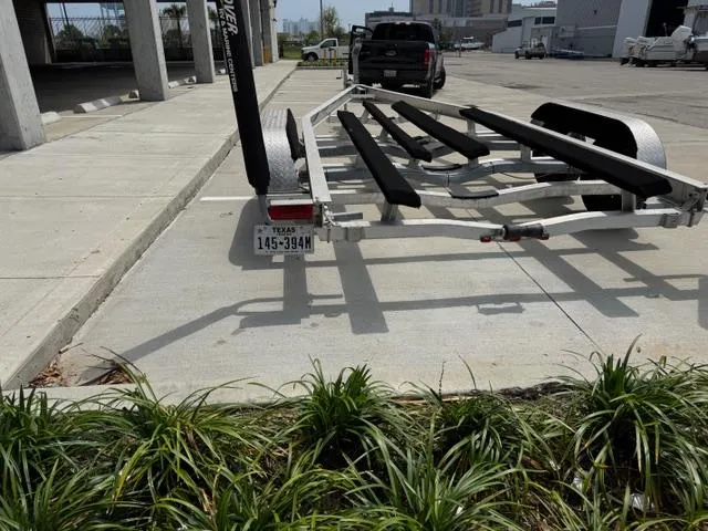 Slide: The Image of Trailer for 2022 Carolina Skiff 23 Ultra Elite parked on concrete near greenery. - 22