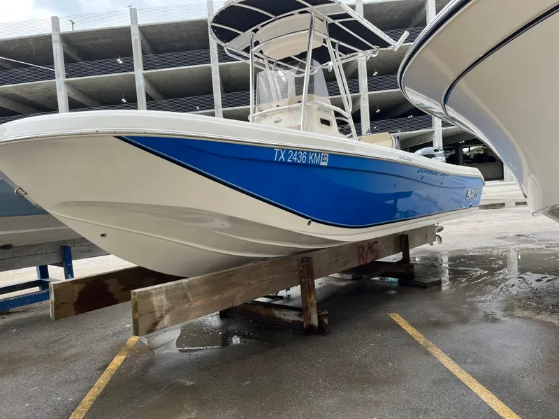 Slide: The Image of 2022 Carolina Skiff 23 Ultra Elite boat in a parking area, blue and white design. - 4
