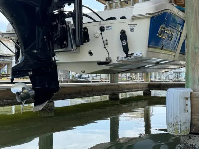 Slide: The Image of 2022 Carolina Skiff 23 Ultra Elite boat docked, showcasing outboard motor and hull. - 6