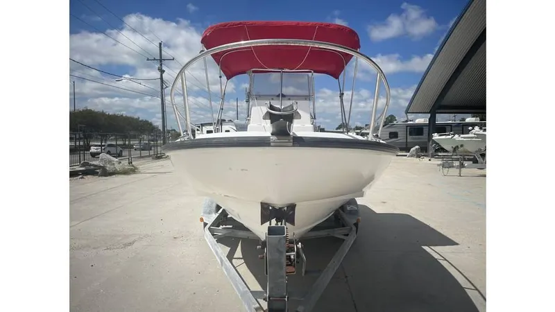 Slide: The Image of 1997 Boston Whaler OUTRAGE boat with red canopy on trailer, front view. - 16