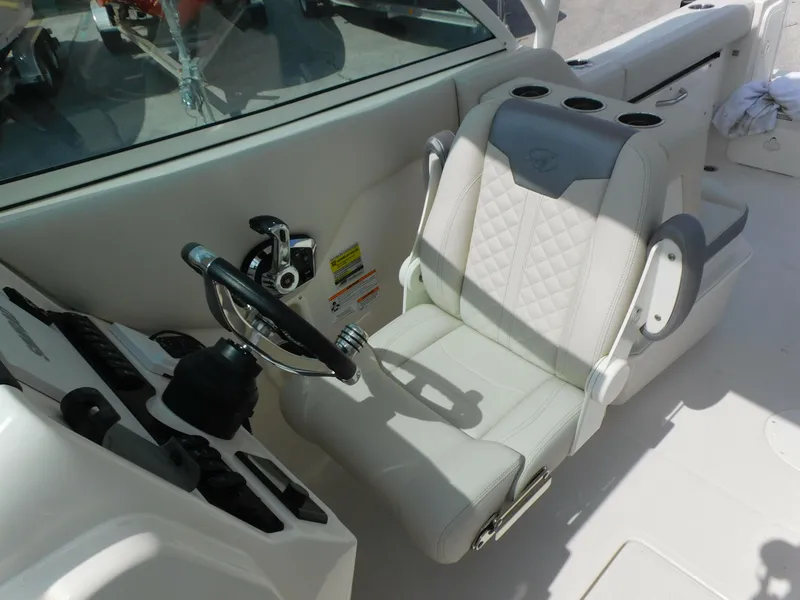 Slide: The Image of 2025 Sailfish 245 DC boat cockpit with steering wheel and cushioned seat. - 13